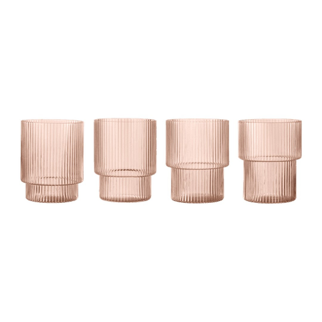 Set of four glass vases in soft rose color with vertical ribbed texture. Elegant and modern design.