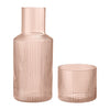 Pair of ribbed glassware in soft pink, featuring a tall carafe and round tumbler, ideal for stylish dining.