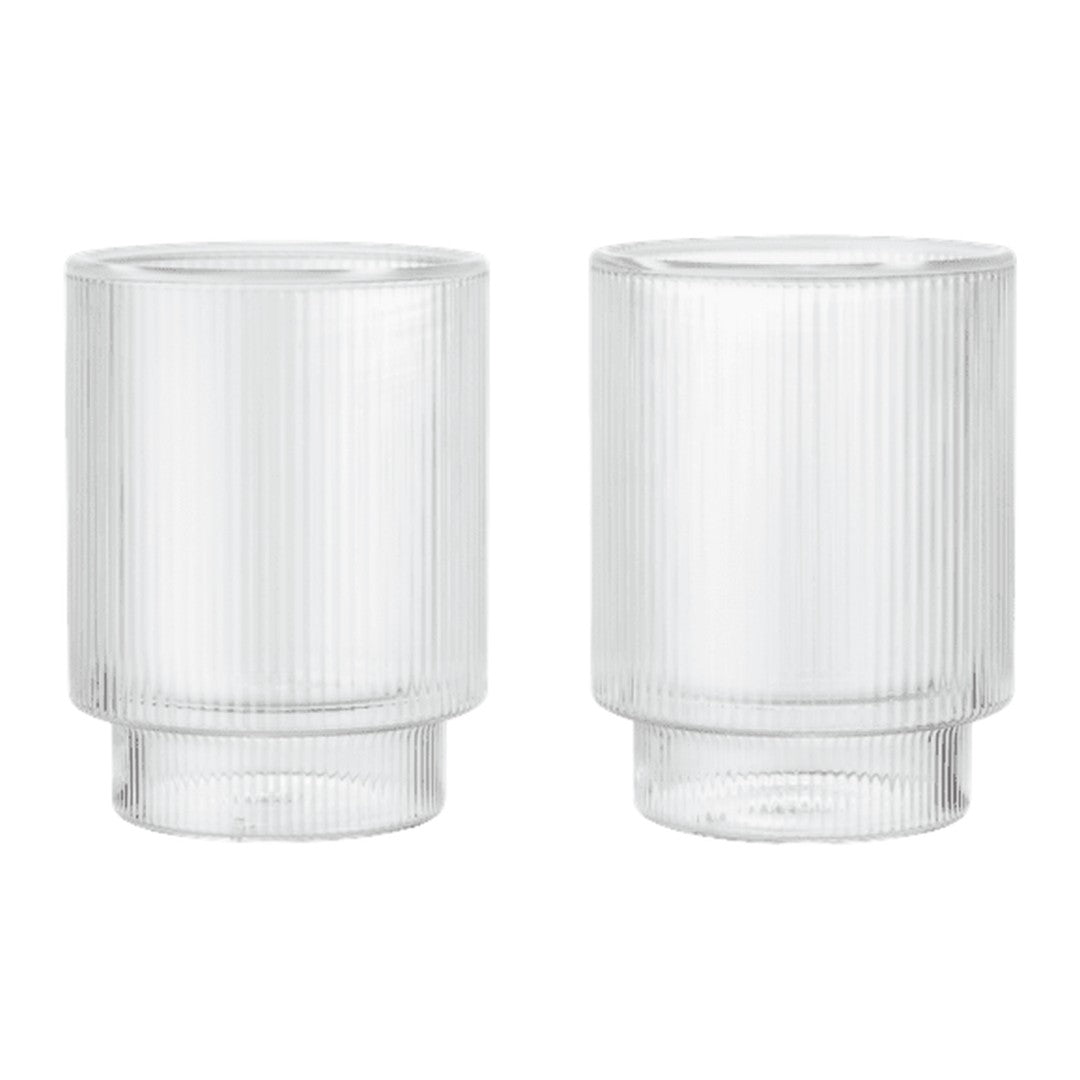 Clear glass tumblers with ribbed texture and smooth, round bases in a minimalist design.