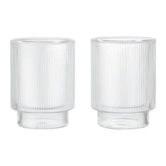 Clear glass tumblers with ribbed texture and smooth, round bases in a minimalist design.