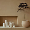 Set of minimalist white vases on a warm, neutral backdrop, featuring smooth textures and soft, organic shapes.