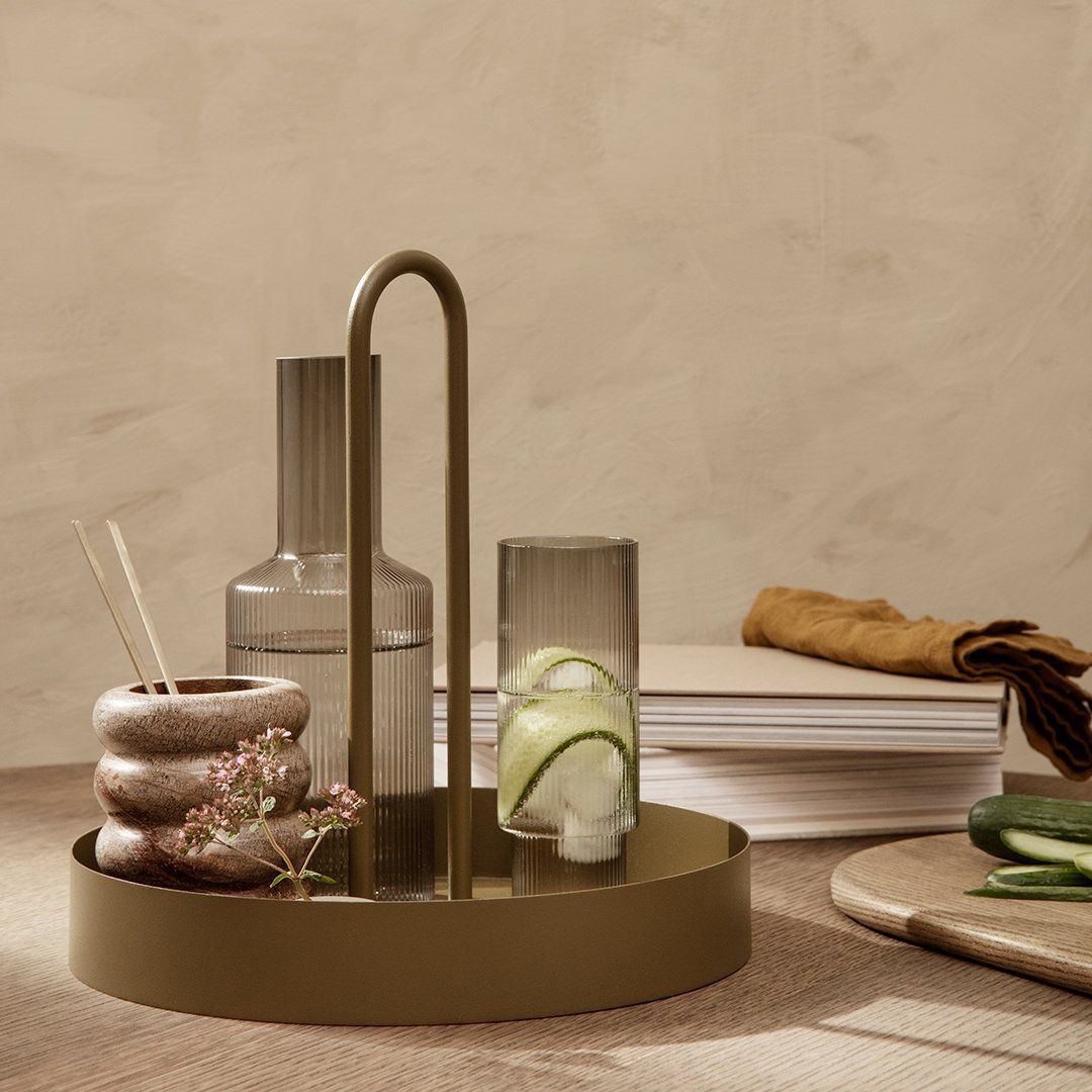 "Elegant olive green tray with minimalist glass and ceramic decor, featuring soft neutral tones and natural textures."