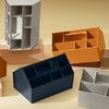 Colorful geometric storage organizers in gray, orange, navy, and beige with various interior compartments.