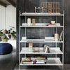 Modern white shelving unit against a dark gray wall, featuring a minimalist design with various neutral-colored decor items.
