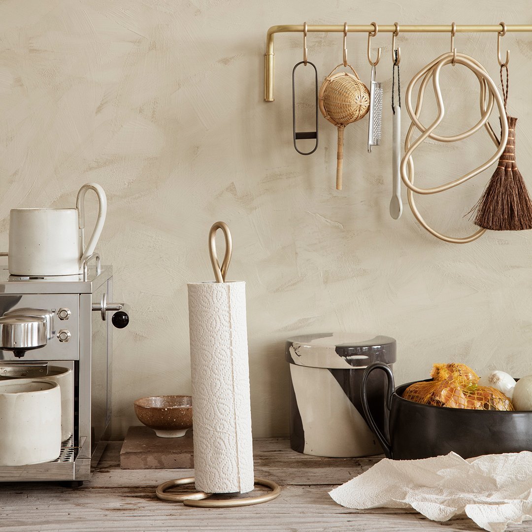 Elegant white paper towel holder with textured pattern against a neutral beige backdrop, featuring gold accents.